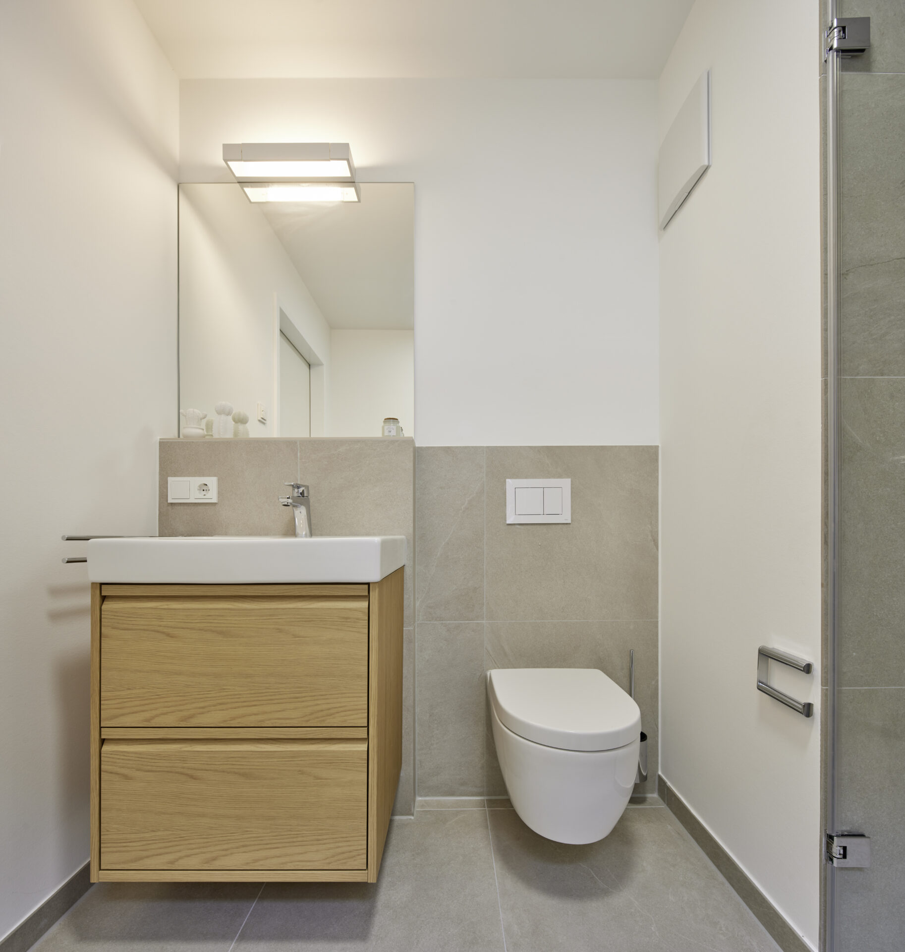 Badezimmer mit schwebendem Holzwaschtisch, Spiegel und WC