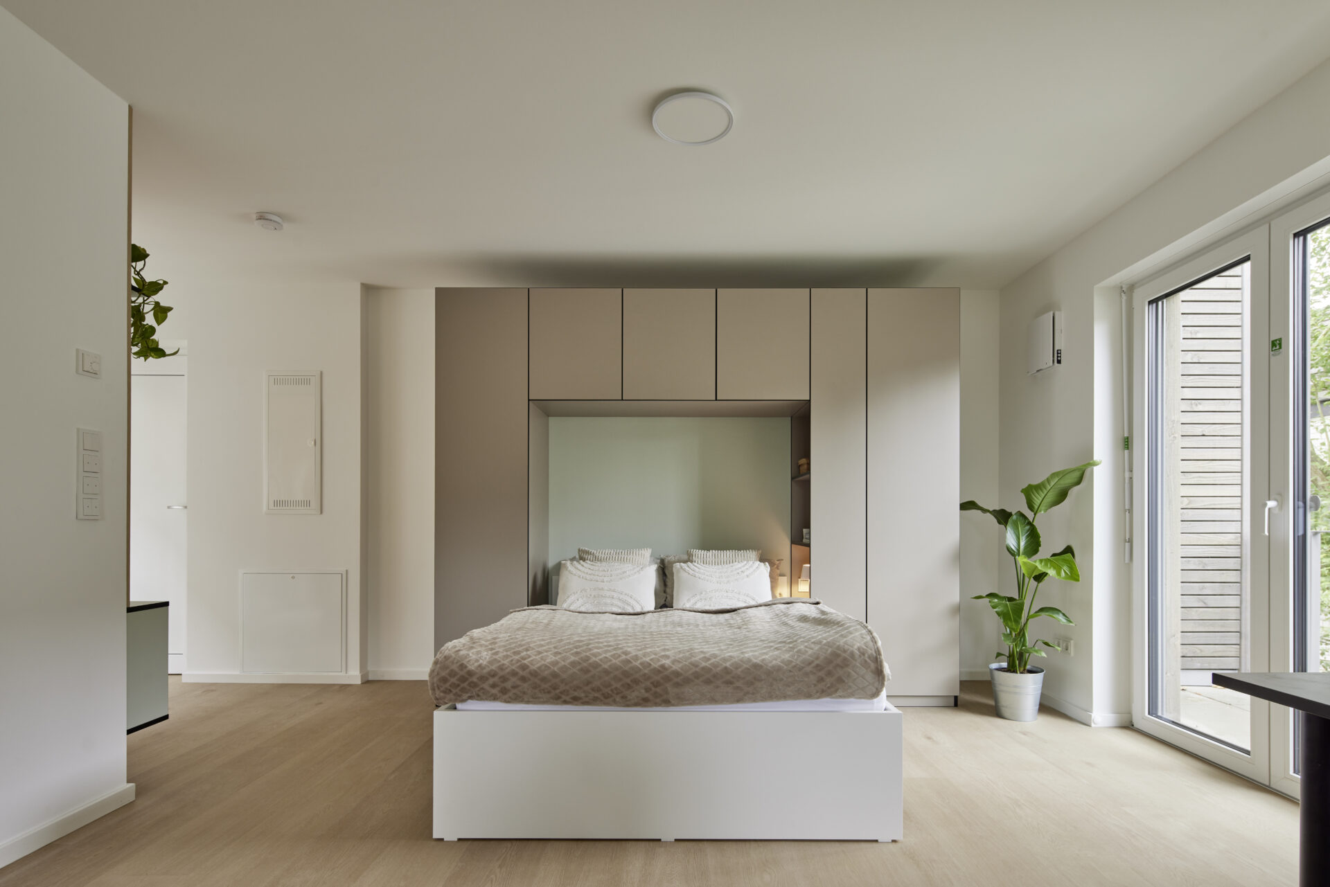 Schlafbereich mit Einbauschrank und direktem Balkonzugang