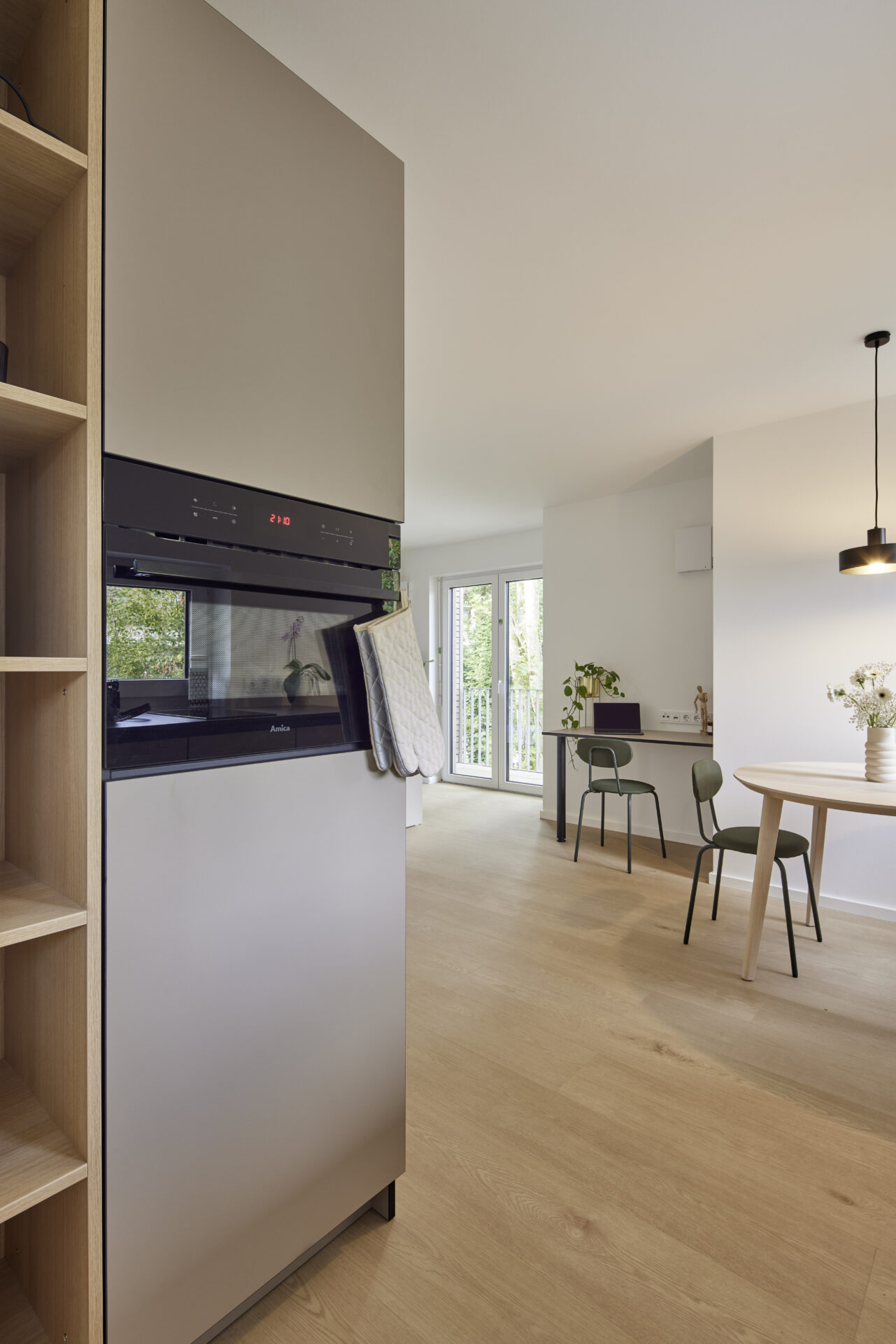 Küchenzeile mit Backofen und Blick in den Wohnbereich