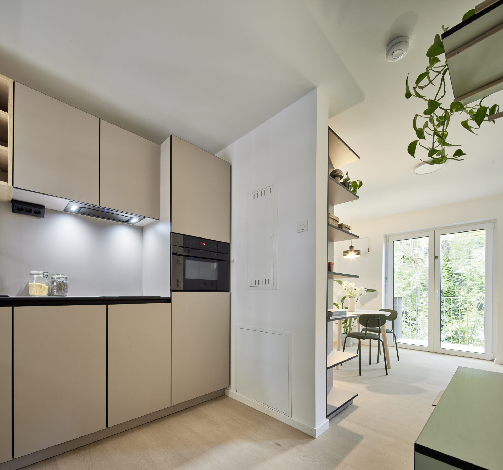 Moderne Einbauküche mit Backofen, Abzug und offenem Wohnbereich