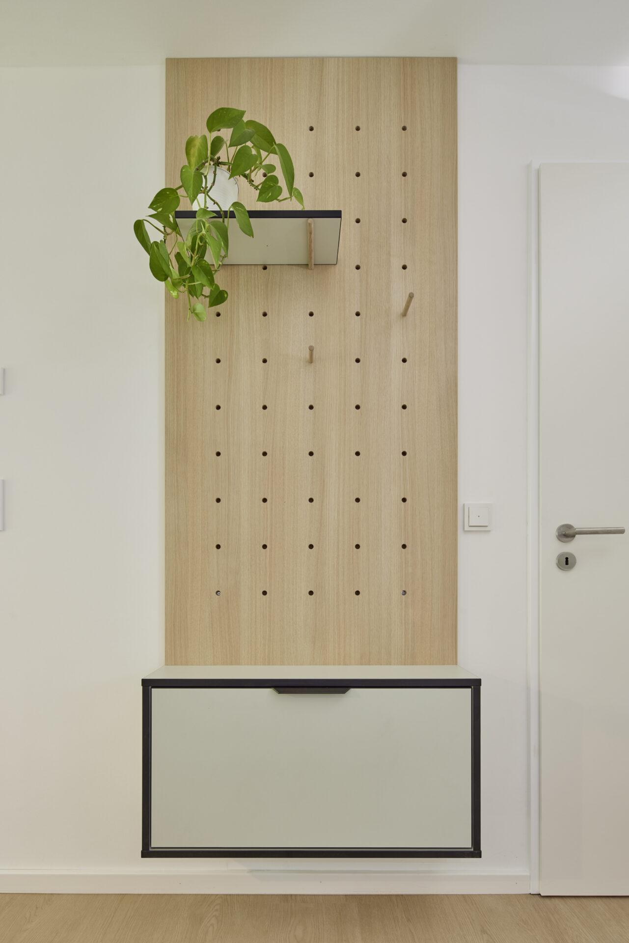 Maßgefertigte Garderobe aus hellem Holz mit Ablage