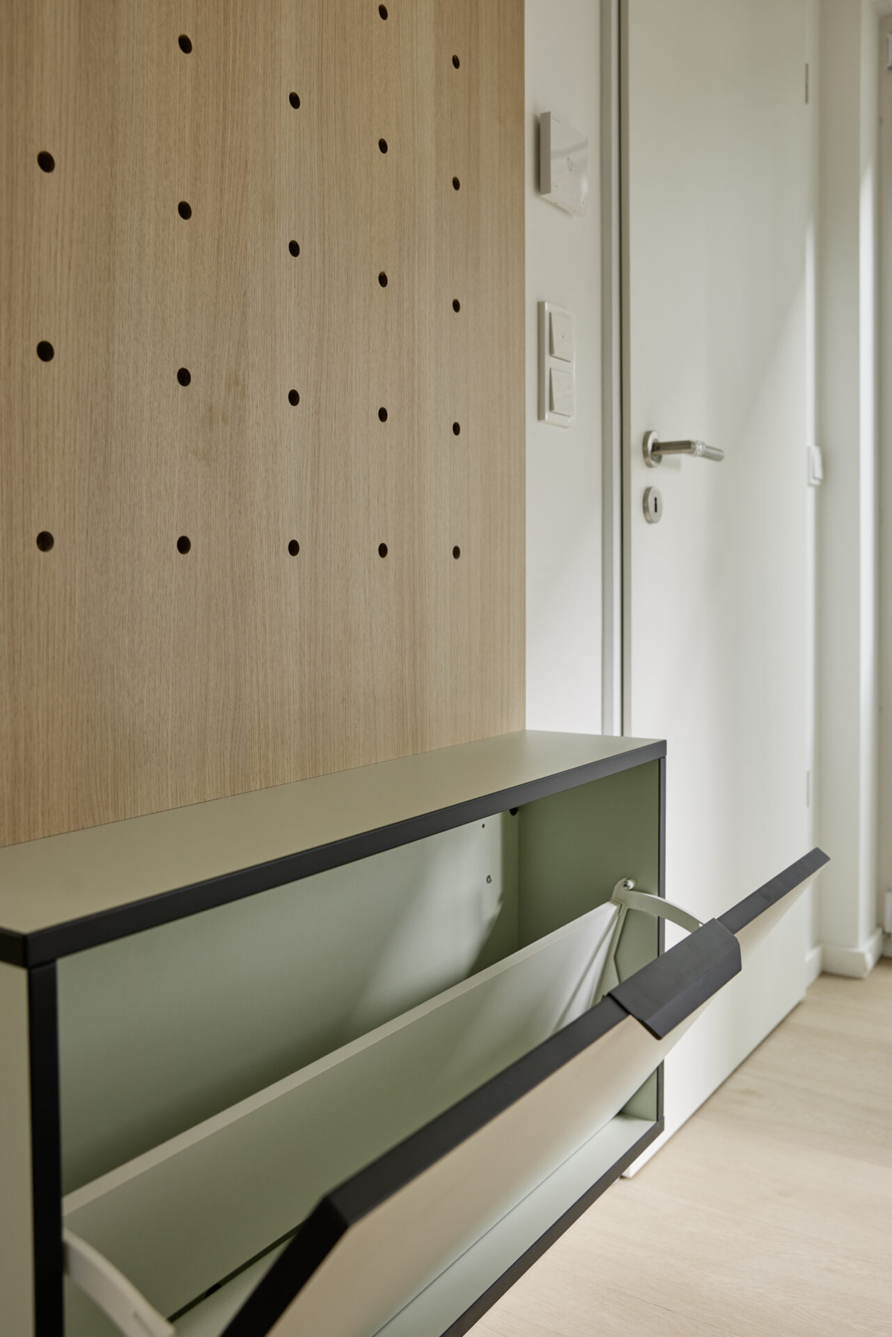 Garderobe mit Lochplatte aus Holz und integriertem Schuhschrank