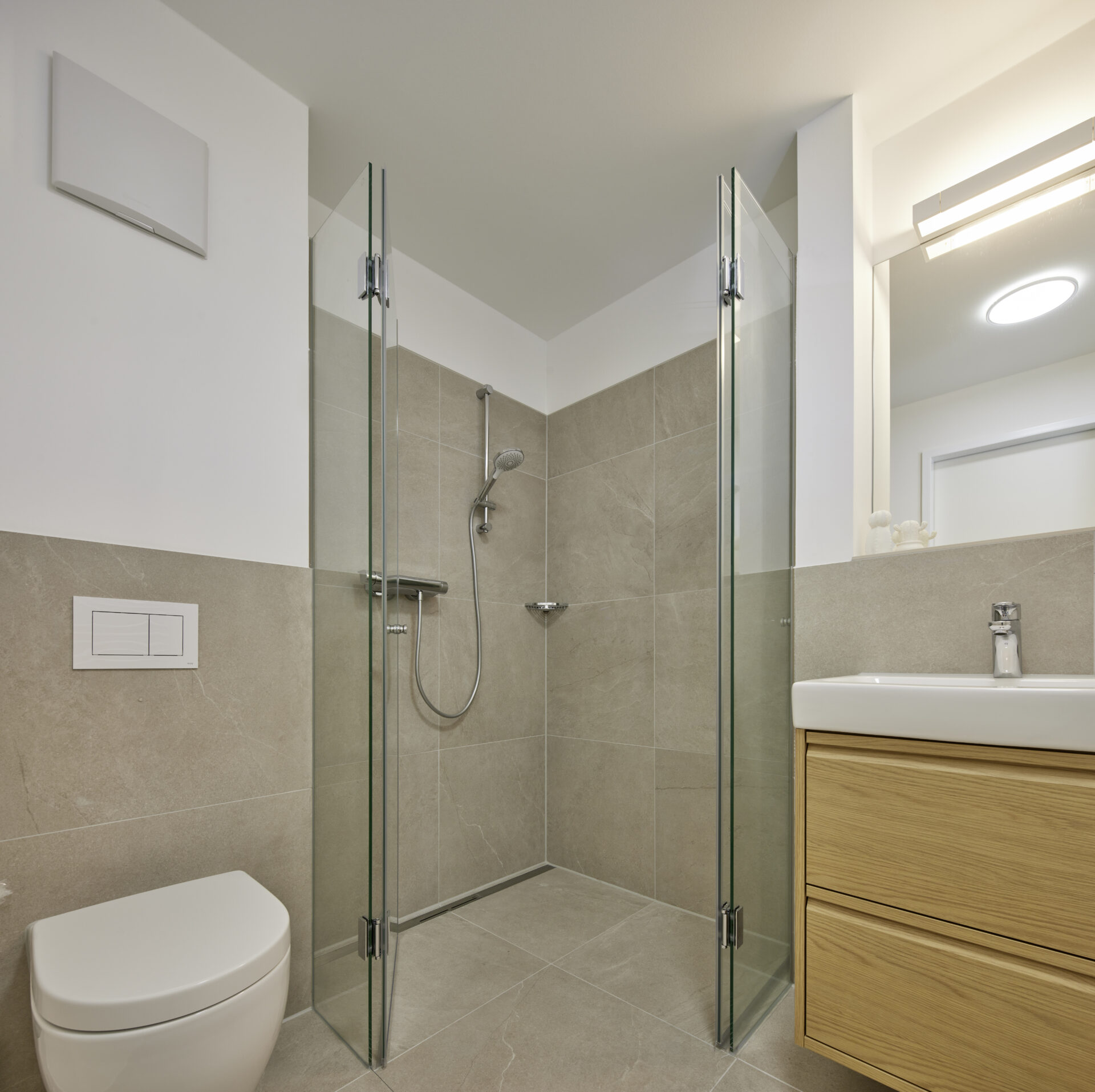 Badezimmer Gesamtansicht mit Dusche, WC und Holzwaschtisch